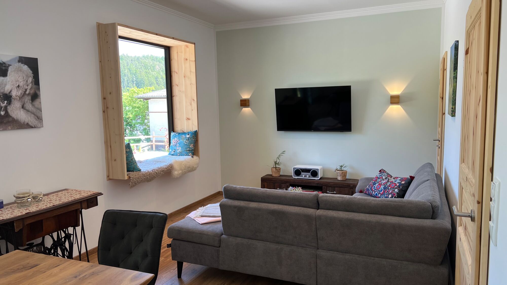 Das Wohnzimmer mit dem Sitzfenster aus duftendem Zirbenholz des Landchalets Eifel auf dem Landgut Pfauenhof